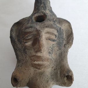 Oil lamp with face in relief