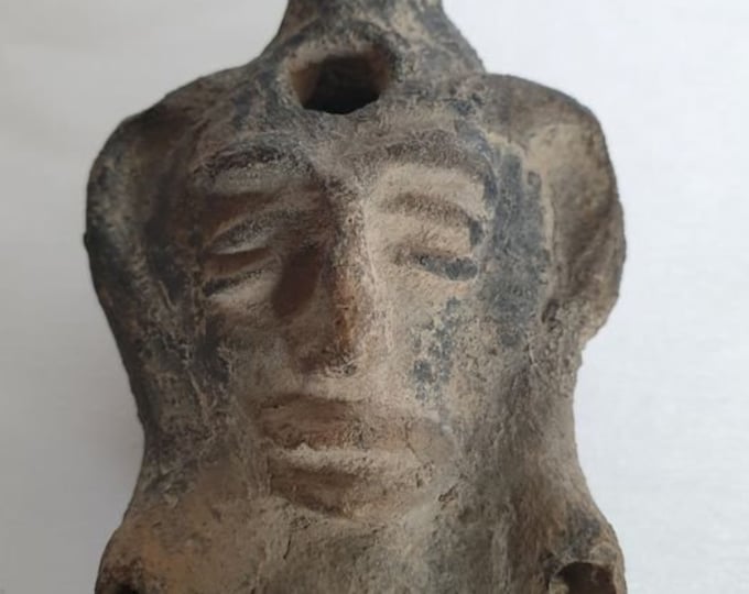 Oil lamp with face in relief