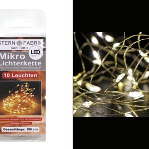 Könnte beinhalten: Eine Packung mit 10 warmweißen LED-Lichterketten mit einer Länge von 100 cm. Die Verpackung ist mit "Mikro Lichterkette" und "STERN FABRIK seit 1983" beschriftet.