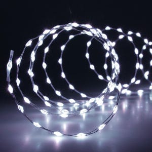 Könnte beinhalten: Eine Lichterkette mit weißen LED-Lichtern, die zu einer Spirale gewickelt ist. Die Lichter sind klein und strahlen ein warmes Weiß aus.
