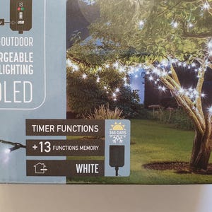 Könnte beinhalten: Eine Box für einen Satz von 240 weißen LED-Solarlichtern. Die Lichter sind wiederaufladbar und haben 13 Timer-Funktionen. Die Box enthält auch einen QR-Code für die Ladehinweise.