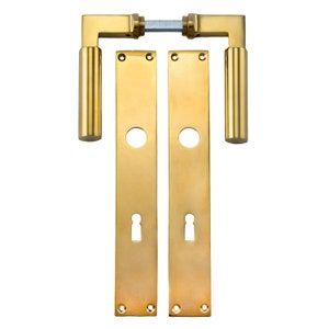 May include: A set of two gold door handles with a cylindrical lever and a rectangular backplate. The backplate has a keyhole and two small holes at the bottom.