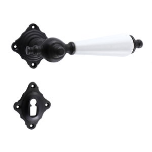 Puede incluir: Pomo de puerta negro con una palanca de cerámica blanca. El pomo tiene una placa posterior cuadrada con bordes decorativos.