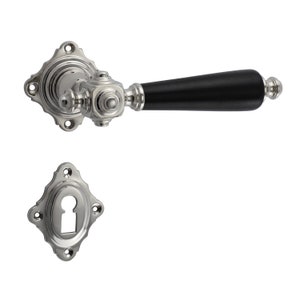 Puede incluir: Una manija de puerta de níquel pulido con una palanca de madera negra. La manija tiene un diseño decorativo y una tapa para el ojo de la cerradura.