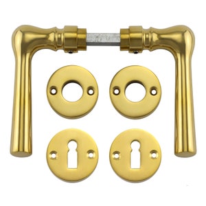Puede incluir: Un juego de herrajes de puerta dorados, que incluye dos manillas de puerta, dos rosetas redondas y dos rosetas redondas con agujeros para llaves.