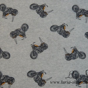 May include: Gray fabric with a repeating pattern of black and white motorcycle illustrations. The motorcycles are all facing the same direction and have a similar design. The fabric is a light gray color and the motorcycles are a dark gray color.
