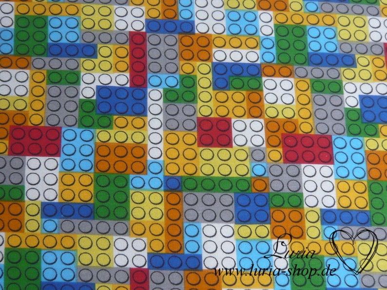 Puede incluir: Una tela colorida con un patr&oacute;n repetitivo de cuadrados y c&iacute;rculos, que se asemeja a bloques de construcci&oacute;n. La tela es una mezcla de amarillo, naranja, rojo, verde, azul, gris y blanco.