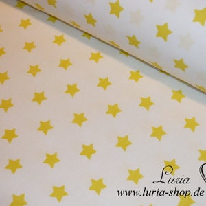 May include: White fabric with a repeating pattern of yellow stars. The fabric is rolled up and the text "Luria www.luria-shop.de" is visible at the bottom of the image.