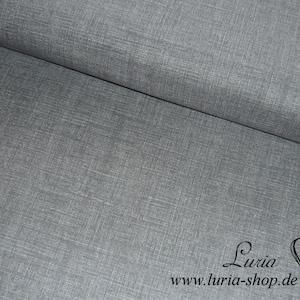 Könnte beinhalten: Grauer Stoff mit einer dezenten gewebten Textur. Der Stoff ist in der Mitte gefaltet und zeigt die Vorder- und Rückseite. Der Stoff ist glatt und weich im Griff. Der Stoff ist perfekt für eine Vielzahl von Nähprojekten, darunter Kleidung, Heimtextilien und Bastelarbeiten.