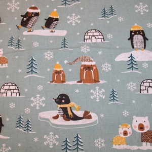 May include: A blue fabric with a repeating pattern of penguins, polar bears, walruses, and igloos. The pattern is in shades of brown, white, and yellow.