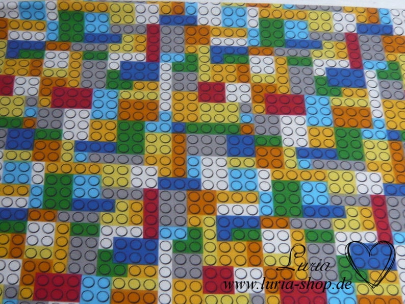 Puede incluir: Una tela colorida con un patr&oacute;n repetitivo de cuadrados y c&iacute;rculos de diferentes colores. Los cuadrados son en tonos de rojo, naranja, amarillo, verde, azul y gris. Los c&iacute;rculos son blancos.