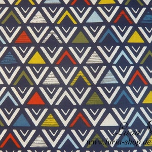 Op de afbeelding: Een donkerblauwe stof met een herhalend patroon van witte, gele, rode, blauwe en groene driehoeken. De driehoeken zijn gerangschikt in een chevron-patroon.