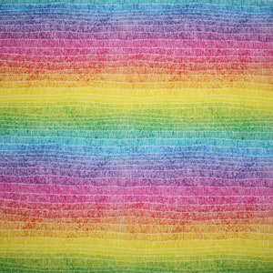 May include: A colourful fabric with a rainbow gradient. The design features horizontal bands of colour, including red, orange, yellow, green, blue, and purple, with white linear details. The overall effect is a vibrant, artistic pattern.