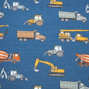 May include: A blue fabric with a repeating pattern of various construction vehicles, including dump trucks, cement mixers, excavators, and cranes. The vehicles are yellow, orange, and gray.