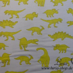 May include: White fabric with a repeating pattern of yellow dinosaurs. The dinosaurs are in various poses, including walking, running, and standing. The fabric is perfect for crafting projects, such as making clothes, bags, and home decor.