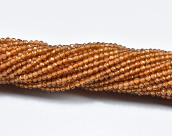 May include: A strand of small, faceted, amber-coloured beads. The beads are round and have a shiny, polished finish.
