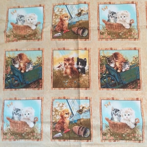 Könnte beinhalten: Stoff mit sich wiederholenden Quadraten, die jeweils Kätzchen in verschiedenen Außenszenen zeigen. Die Illustrationen zeigen Kätzchen in einer Schubkarre, einem Korb und einem Garten mit Schmetterlingen und einem Blumentopf. Die Kätzchen sind braun, grau und weiß.