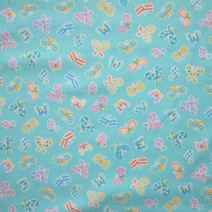 Könnte beinhalten: Ein türkisfarbener Stoff mit einem sich wiederholenden Muster aus bunten Schmetterlingen. Die Schmetterlinge sind in verschiedenen Schattierungen von Rosa, Gelb, Blau, Grün und Orange.