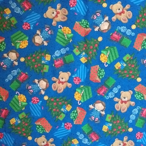 Könnte beinhalten: Ein blauer Stoff mit einem sich wiederholenden Muster aus Weihnachtsbäumen, Teddybären, Puppen und Geschenken. Die Geschenke sind in grünes, rotes und blaues Papier mit weißen Streifen verpackt.