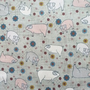 Könnte beinhalten: Ein hellgrüner Stoff mit einem sich wiederholenden Muster aus rosa, weißen und grauen Schweinen. Die Schweine sind in einem einfachen, cartoonartigen Stil gezeichnet und von kleinen blauen, roten und gelben Blumen umgeben.