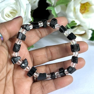 May include: Black tourmaline and clear quartz beaded bracelet. The bracelet is made with faceted black tourmaline and round clear quartz beads.