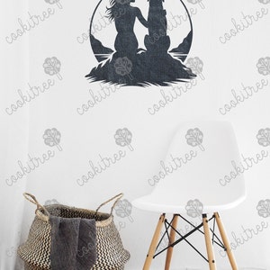 May include: A dark gray metal wall art piece depicting a woman and a dog within a circular frame. The art is mounted on a white wall, with a white chair and a woven basket in the foreground.