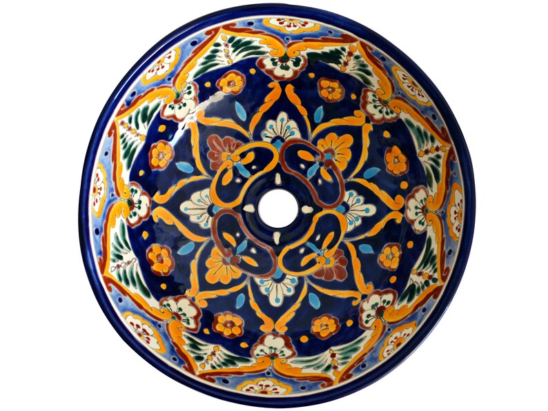 May include: A round, hand-painted ceramic sink basin with a vibrant floral design. The sink features a deep blue background with intricate patterns in yellow, orange, white, and green. A central drain hole is visible.