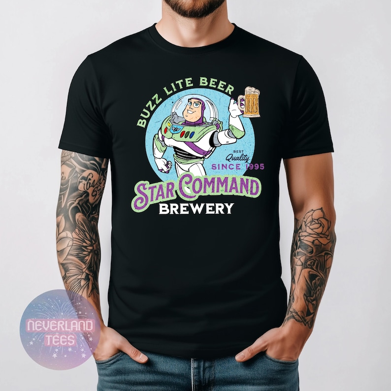 May include: Black t-shirt featuring a cartoon Buzz Lightyear character holding a beer mug. The design includes the text "Buzz Lite Beer" and "Star Command Brewery" with "Best Quality Since 1995".