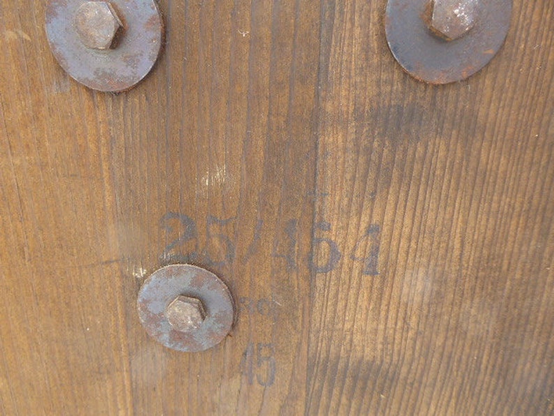 May include: Close-up of a wooden surface with three metal fasteners and the text "25/11/51" written in black ink.