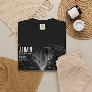May include: A black short-sleeved t-shirt featuring a white graphic print with the text AI RAIN REALITY CODE, binary code patterns, a mathematical equation, and a network diagram. The shirt has a crew neckline and a Comfort Colors brand label.