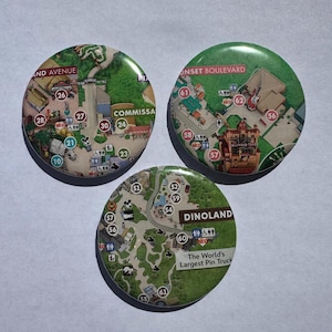 May include: A white ceramic mug with a black handle and the text "But First, Coffee" in a bold, black font. The mug is set against a blurred background, suggesting a cozy setting.