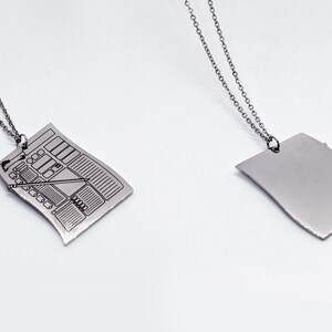 Front and back view of silver character sheet necklace pendant. Perfect D&D character sheet jewelry for RPG fans wanting a subtle fantasy accessory.
