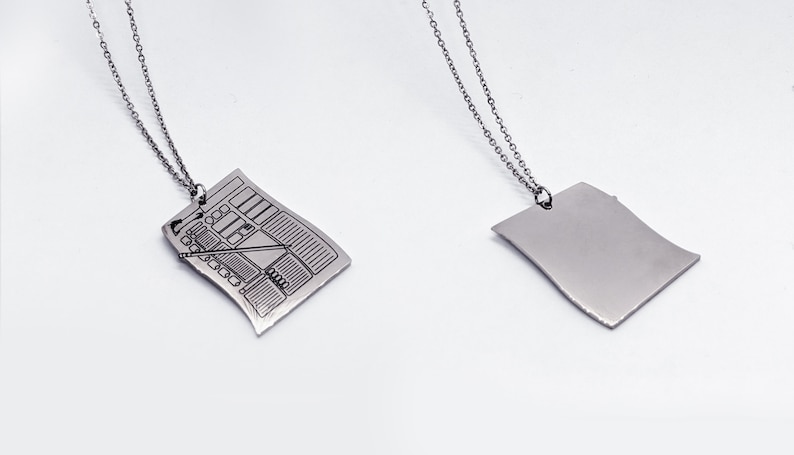 Front and back view of silver character sheet necklace pendant. Perfect D&D character sheet jewelry for RPG fans wanting a subtle fantasy accessory.