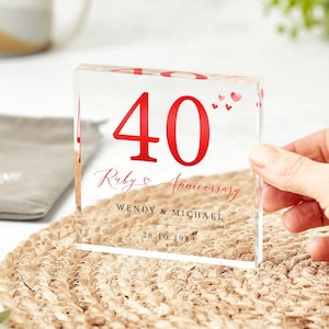May include: A clear acrylic block with the number 40 in red, the words "Ruby Anniversary" in cursive, and the names "Wendy & Michael" and the date "28.10.1983" in black.