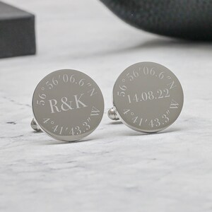 May include: A pair of silver cufflinks engraved with coordinates and the initials "R&K".