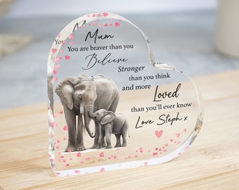 May include: A heart-shaped crystal paperweight with a mother and baby elephant design. The paperweight has pink glitter hearts and the text "Mum You are braver than you believe Stronger than you think and more Loved than you'll ever know Love Steph x".