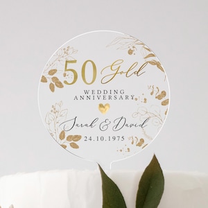 May include: Gold 50th wedding anniversary cake topper with a floral design and the text "50 Gold Wedding Anniversary Sarah & David 24.10.1975".