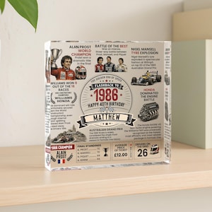 May include: A clear acrylic block featuring a 1986 Formula One themed birthday print for Matthew. The design includes text about Alain Prost, Nigel Mansell, race statistics, a Honda engine illustration, and a vintage race car graphic in black and red.