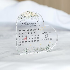 May include: A clear heart-shaped acrylic keepsake with a floral design and the words "Married" and "September 2024". The calendar shows the date "17" highlighted with a red heart. The names "Amelia & Michael" are also included.