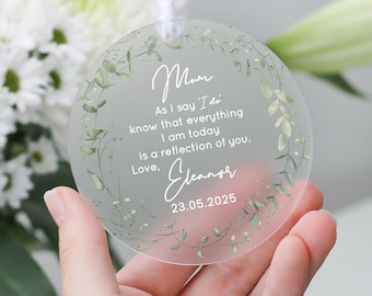 May include: A clear, round ornament with a white ribbon for hanging. The ornament features the word "Mum" and a heartfelt message in elegant script, surrounded by a delicate green floral design. The date "23.05.2025" is also included.
