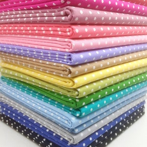 May include: A stack of 15 fabric squares with white polka dots on a variety of coloured backgrounds, including red, pink, light pink, lavender, beige, yellow, green, turquoise, light blue, grey, blue, and navy.