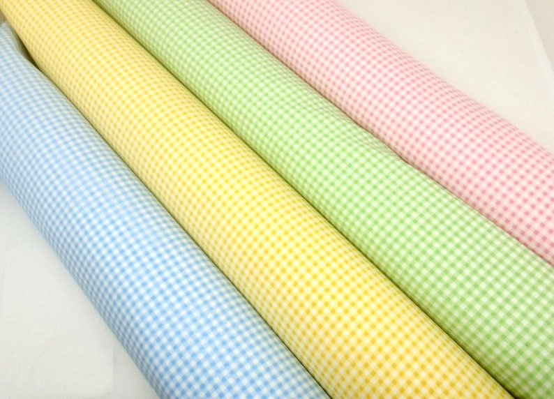May include: Four rolls of gingham fabric in blue, yellow, green, and pink.