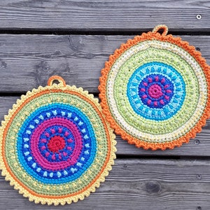 a pair of crocheted, round, cotton potholders
