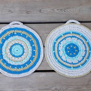 a pair of crocheted, round, cotton potholders