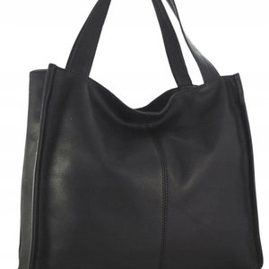 May include: A black tote bag with two handles. The bag is made of a smooth, matte material and features a vertical seam down the center. The handles are attached at the top of the bag and are the same color as the bag.