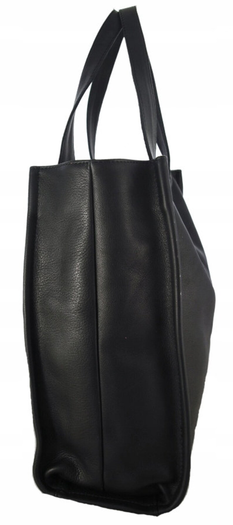 May include: A black tote bag with two long handles. The bag is made of a textured material and has a rectangular shape. The handles are attached to the top of the bag.