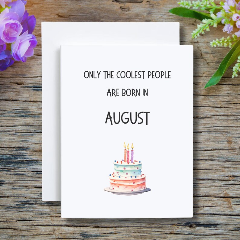 May include: White card with the text "Only the coolest people are born in August" and a watercolor illustration of a three-tiered birthday cake with pink, blue, and white frosting and four lit candles.