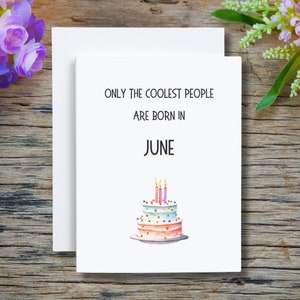 May include: White card with black text that reads "Only the coolest people are born in June". A watercolor illustration of a pink and blue layered cake with four lit candles is below the text.