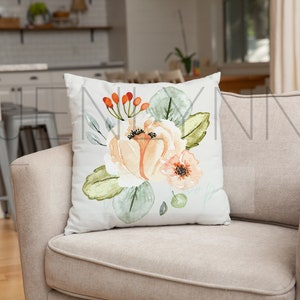 May include: A throw pillow with a floral design featuring peach and orange flowers with green leaves and red berries on a white background.
