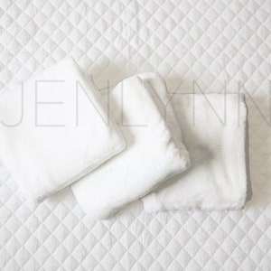May include: Three white, fluffy, rectangular pillows arranged on a white quilted surface. The pillows are soft and plush, perfect for a cozy and comfortable setting.